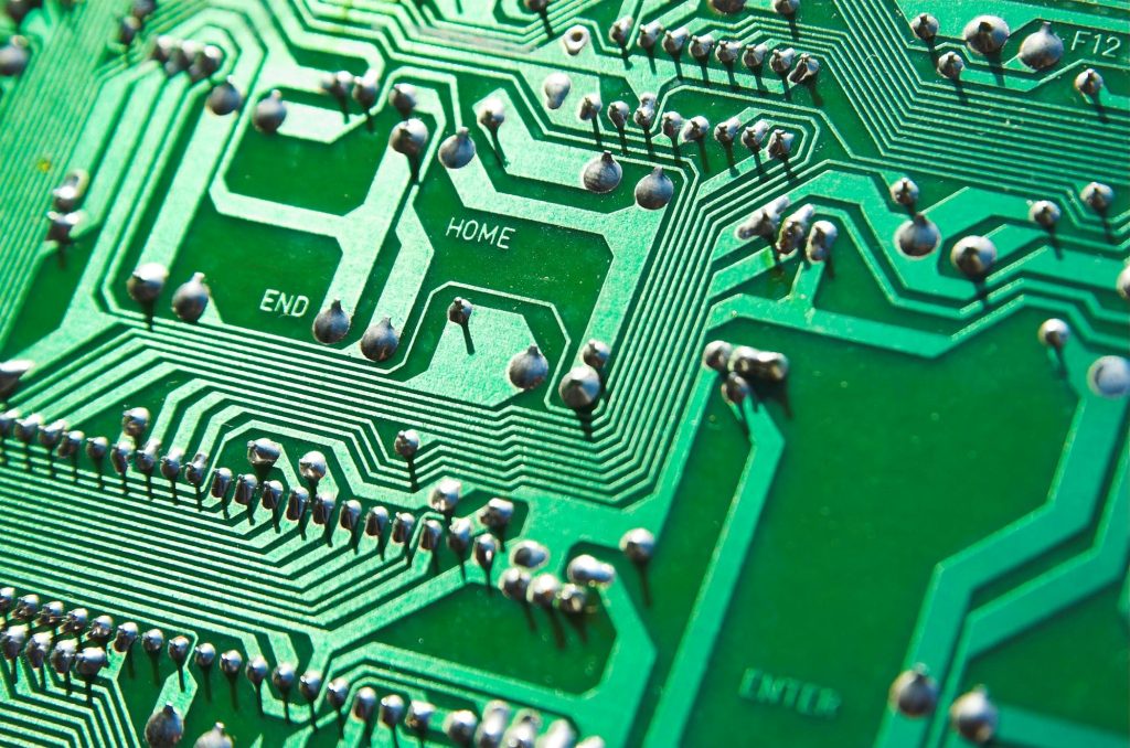 pexels-photo-459411-459411 Detailed view of green circuit board with visible chips and pathways, highlighting technology elements.